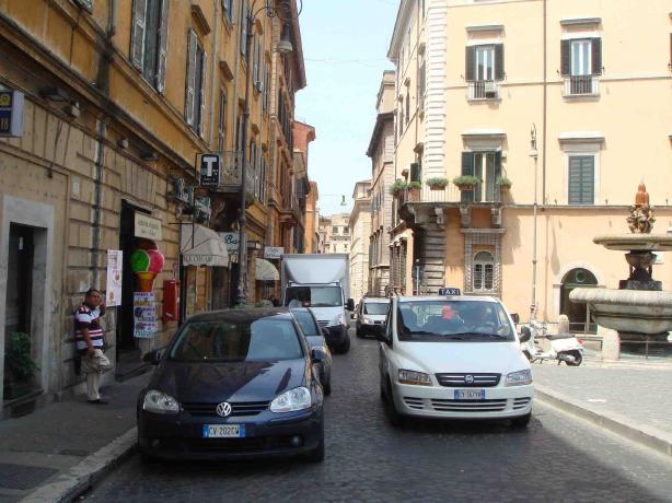 ローマの裏道。路上駐車の横を車が走る。歩道は狭い。このような道に信号機はありません。